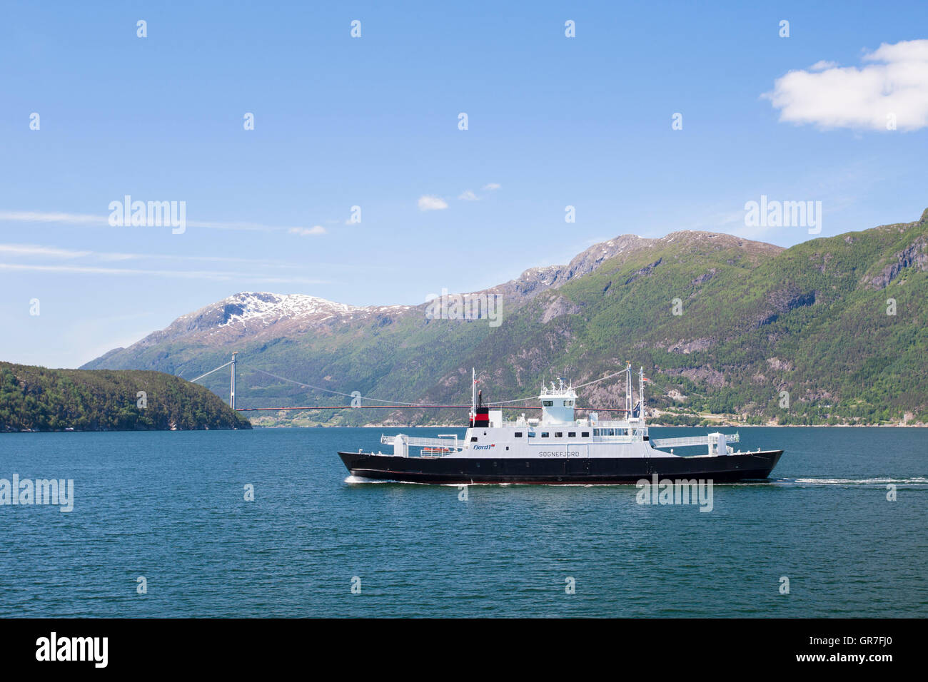 Fjord 1 ferry (the Sognefjord) crossing Hardangerfjord, with Hardanger Bridge (Hardangerbrua) behind, Hordaland, Norway Stock Photo