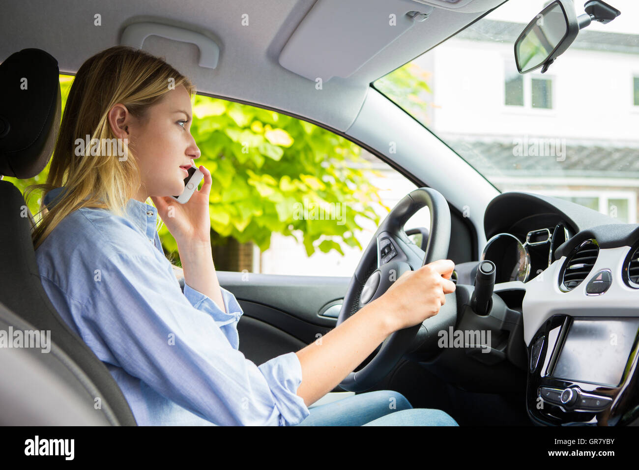 Woman In Car Talking On Mobile Phone Whilst Driving Stock Photo