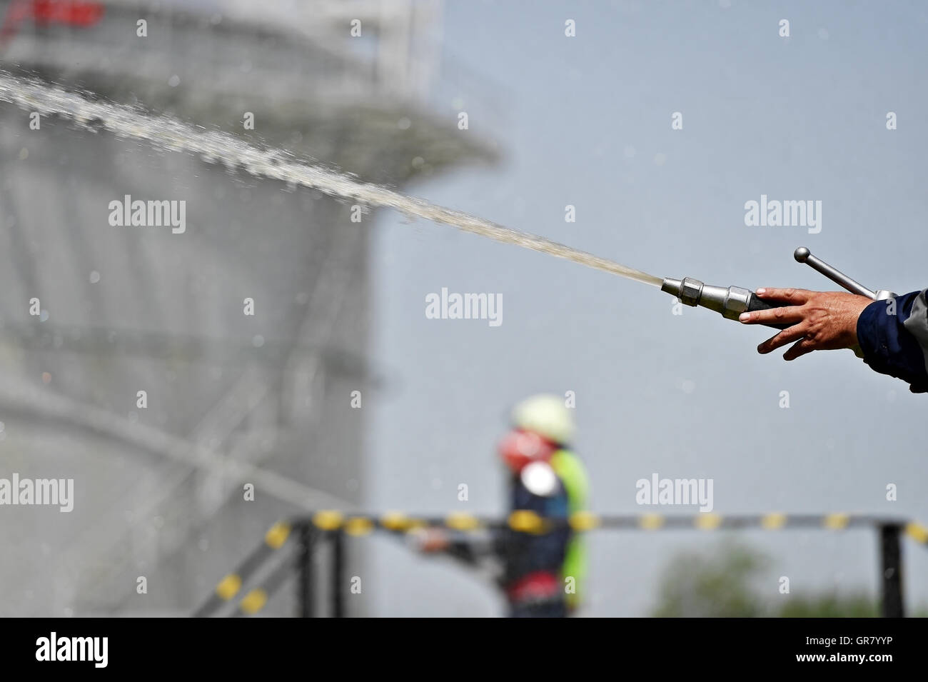 Firefighter holding high pressure water hose extinguishing a fire ...