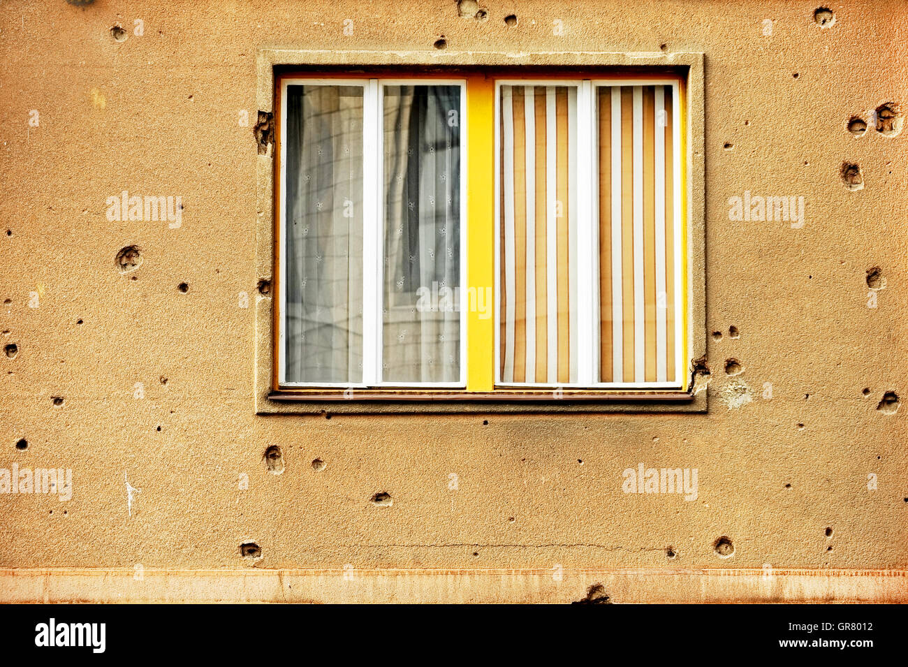 Traces of bullets on a building facade destroyed by war Stock Photo