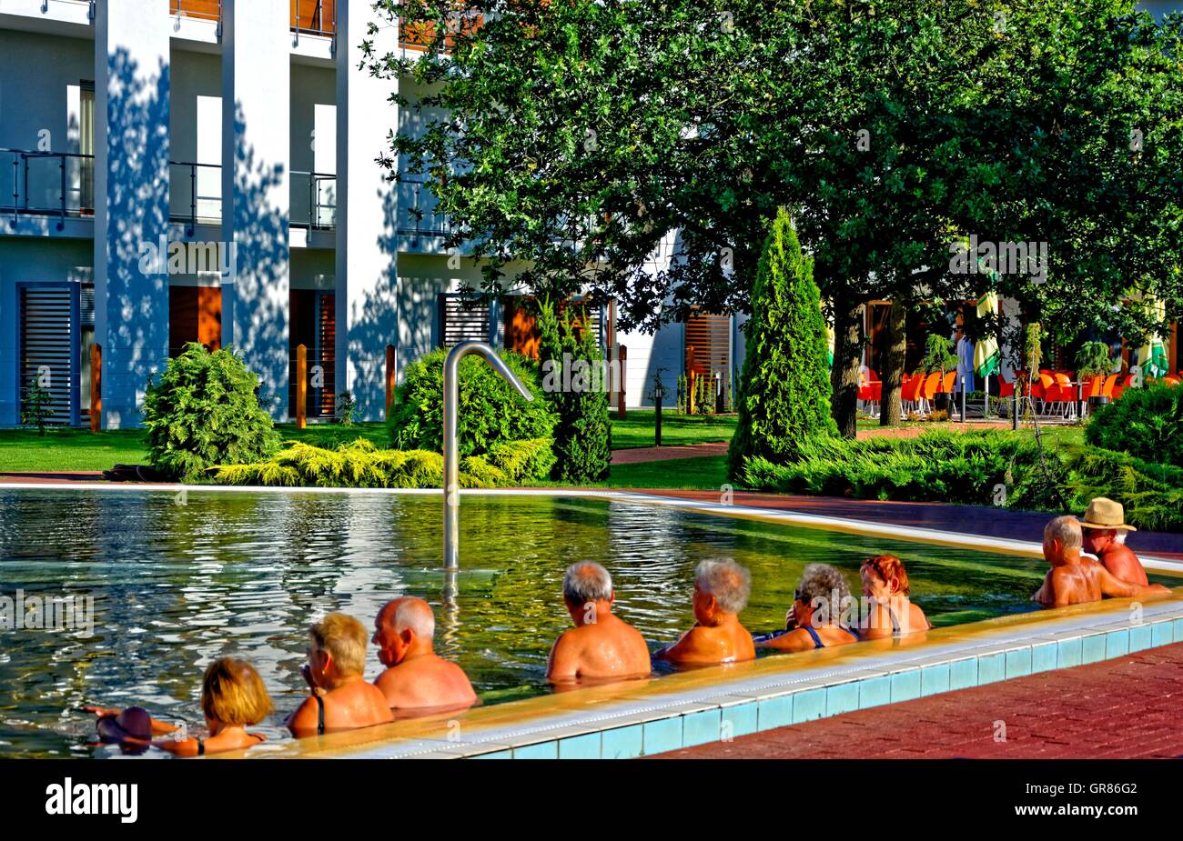 Seniors Sitting In A Row In The Thermal Waters Stock Photo