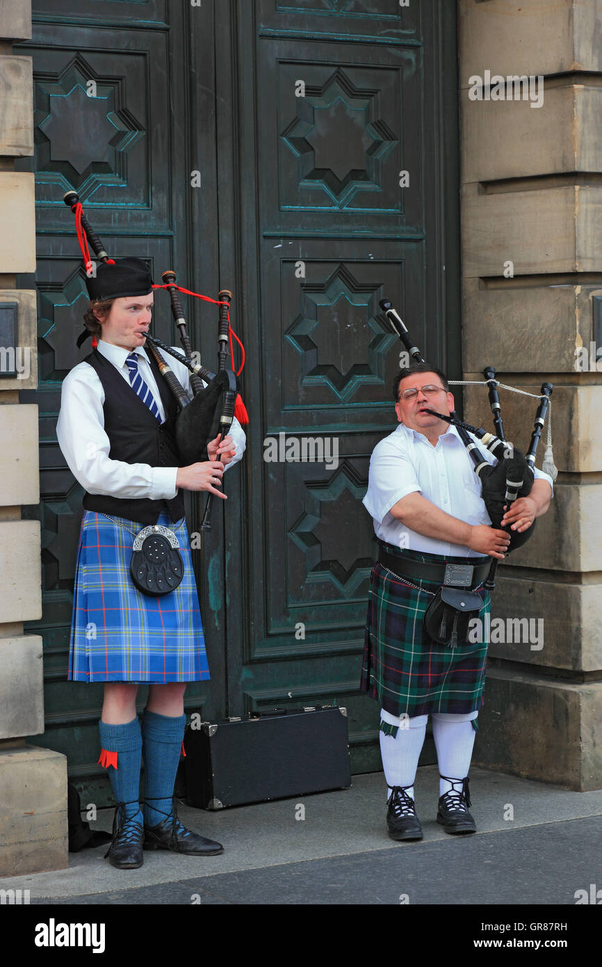 Scotland, Edinburgh, two bagpipe players in the High Street, Piper carry kilt or Tartan Stock Photo