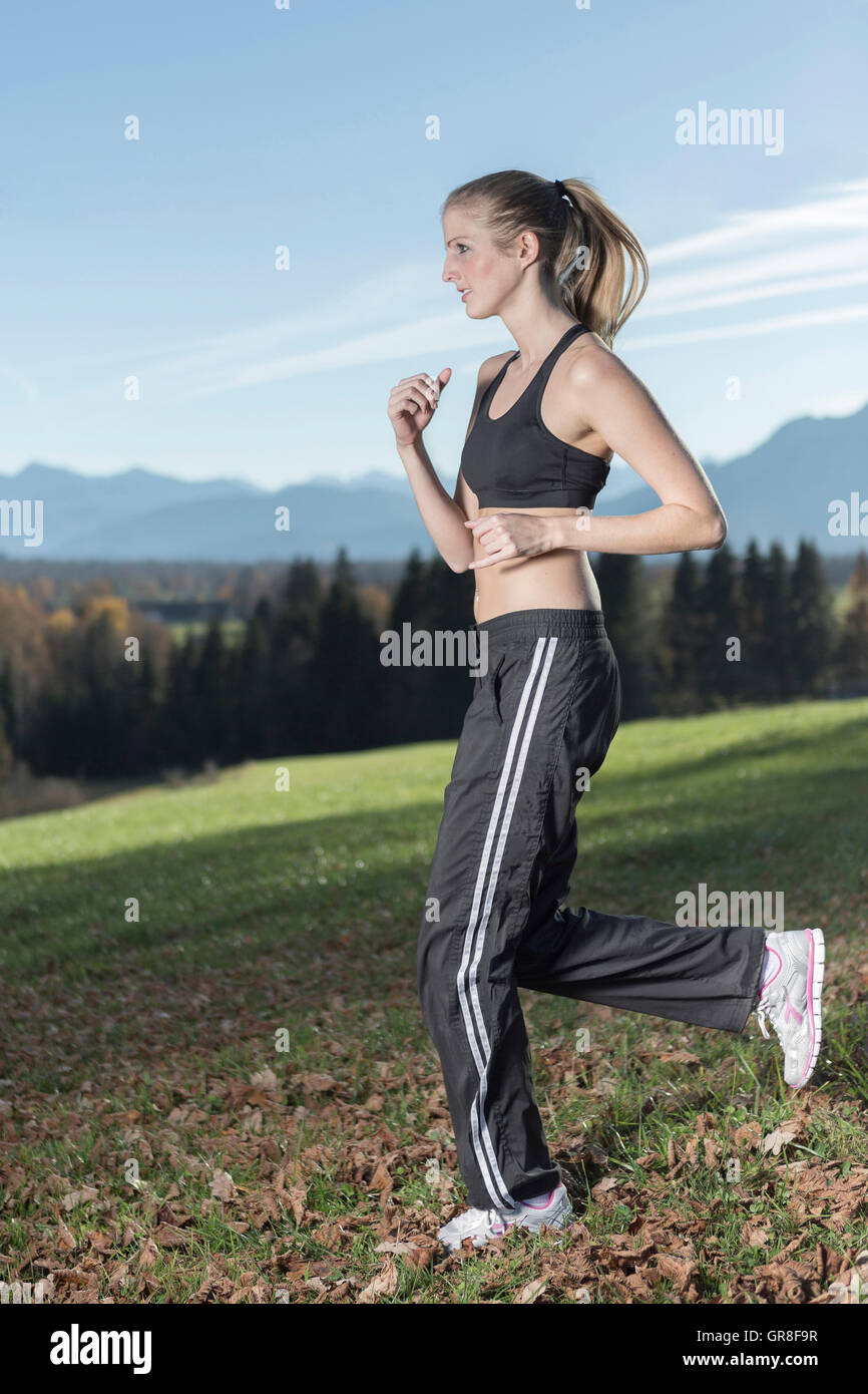 Young Woman With A Sporty Outfit Operates Jogging In The Nature Stock Photo  - Alamy