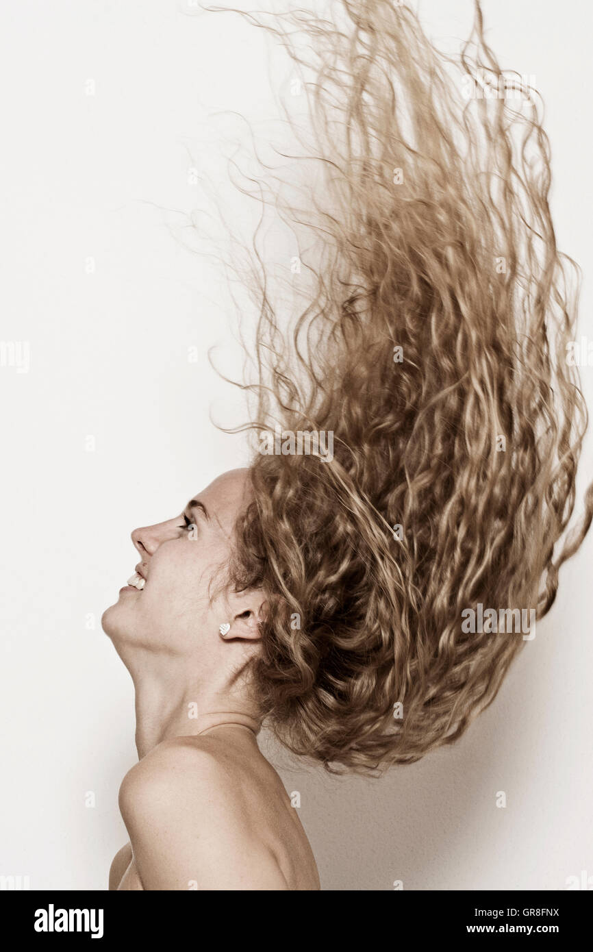 Young Vivacious Woman Lets Her Hair Fly Stock Photo