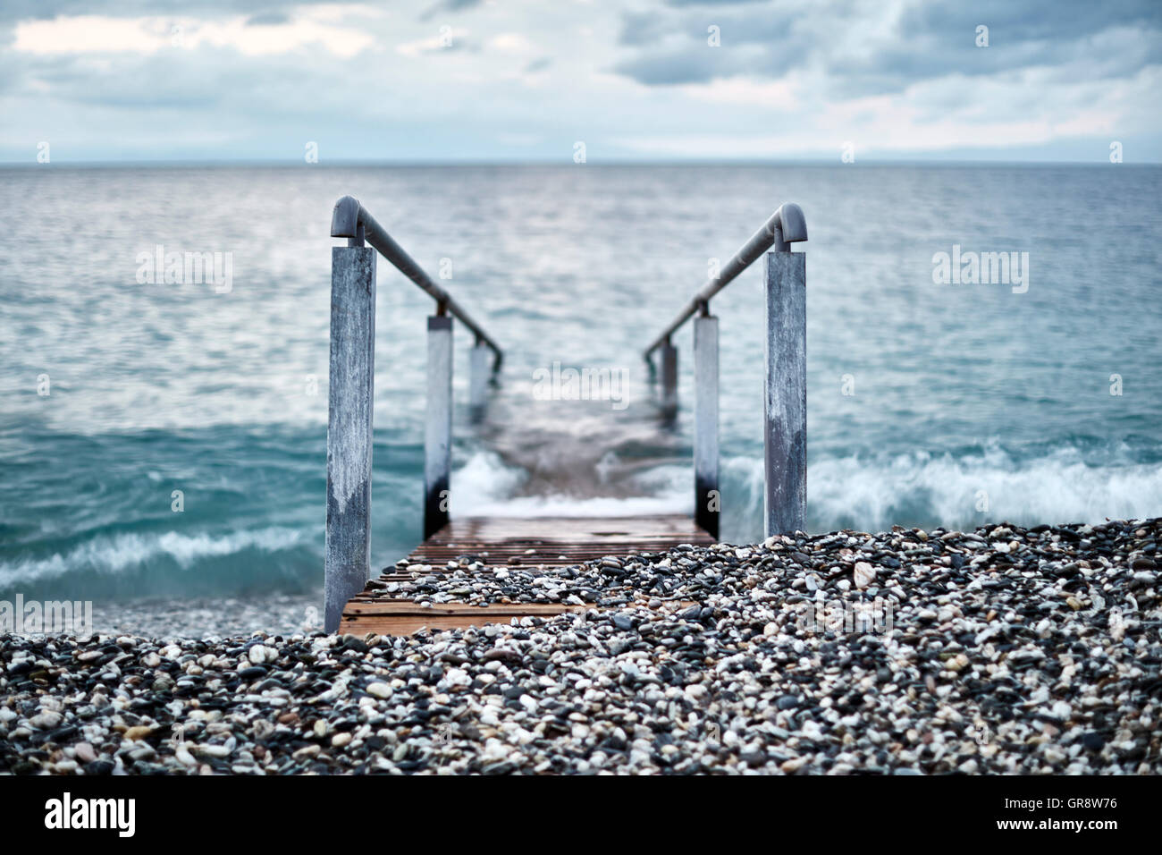 Ramp with railing leading into ocean, Devon, United Kingdom Stock Photo