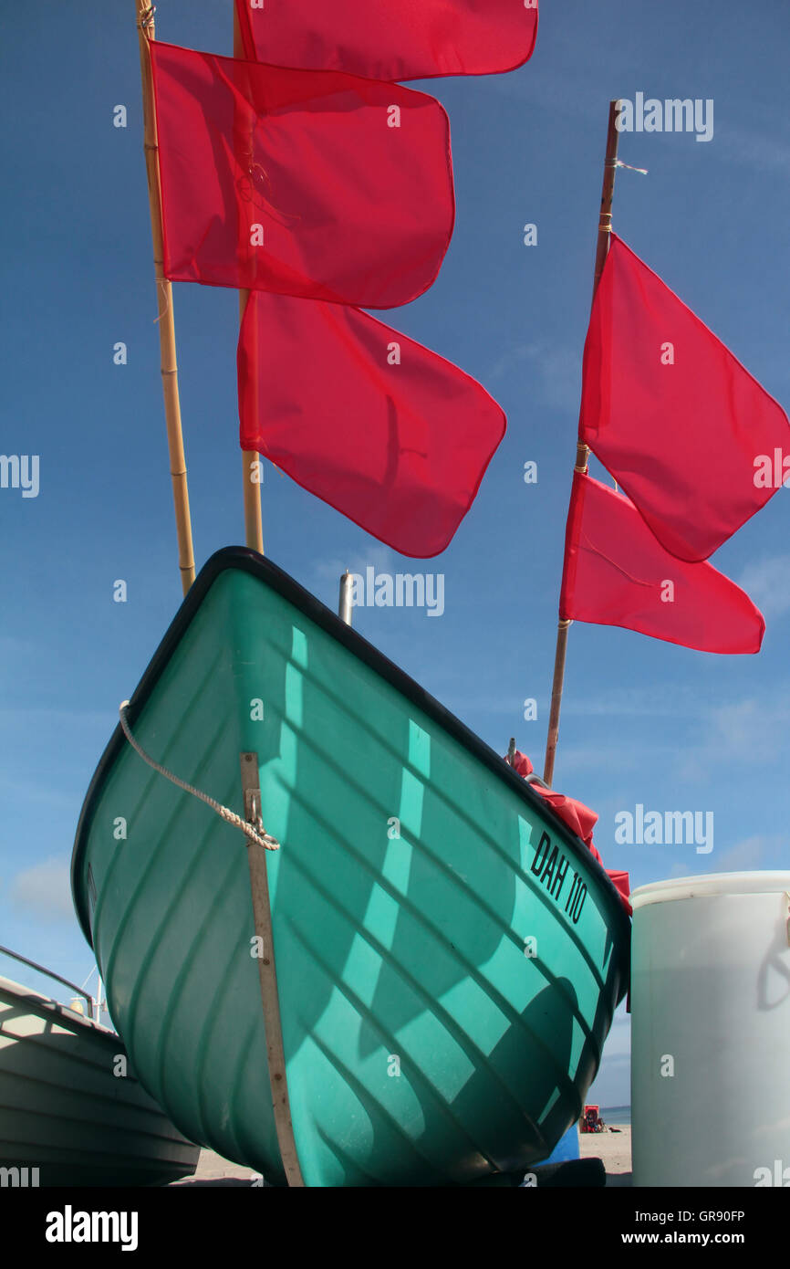 Boat With Red Flags On The German Baltic Sea Beach Stock Photo