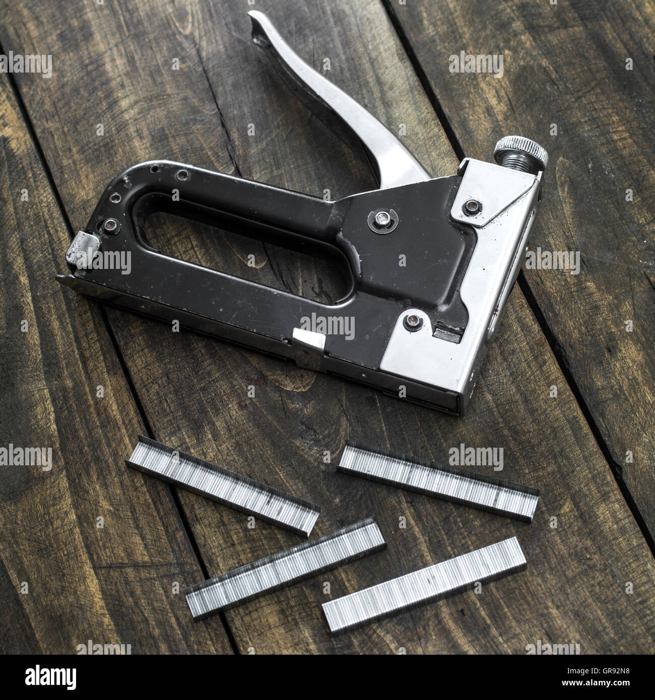 Carpentry stapler ,Construction machinery held stapler on wooden background Stock Photo