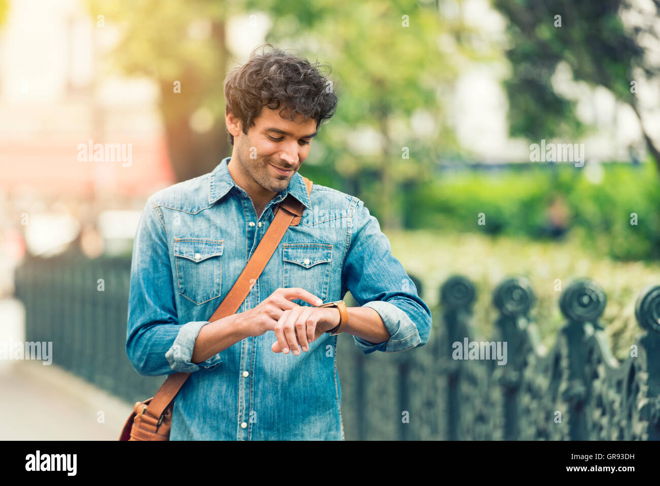 Man in the street using his smart-watch app. Urban background Stock ...