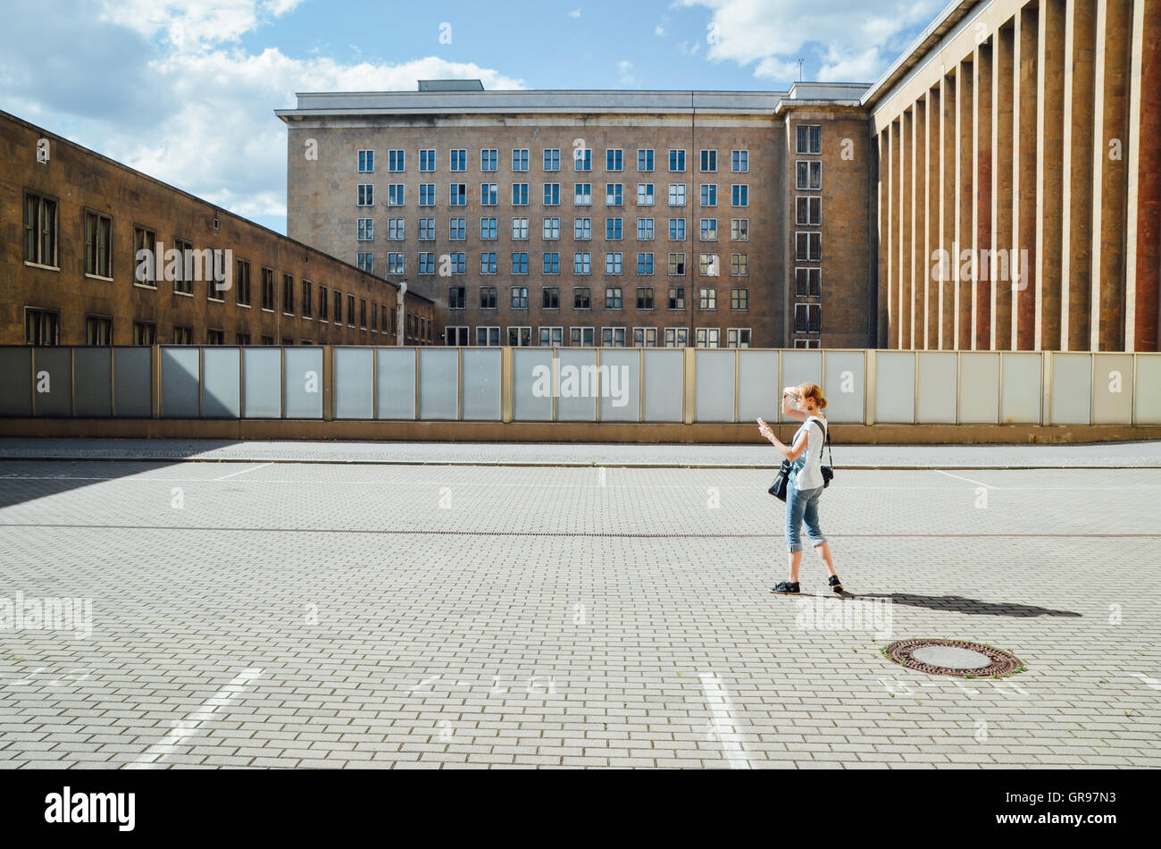 Full Length Side View Of Woman Photographing On Street Against Buildings Stock Photo