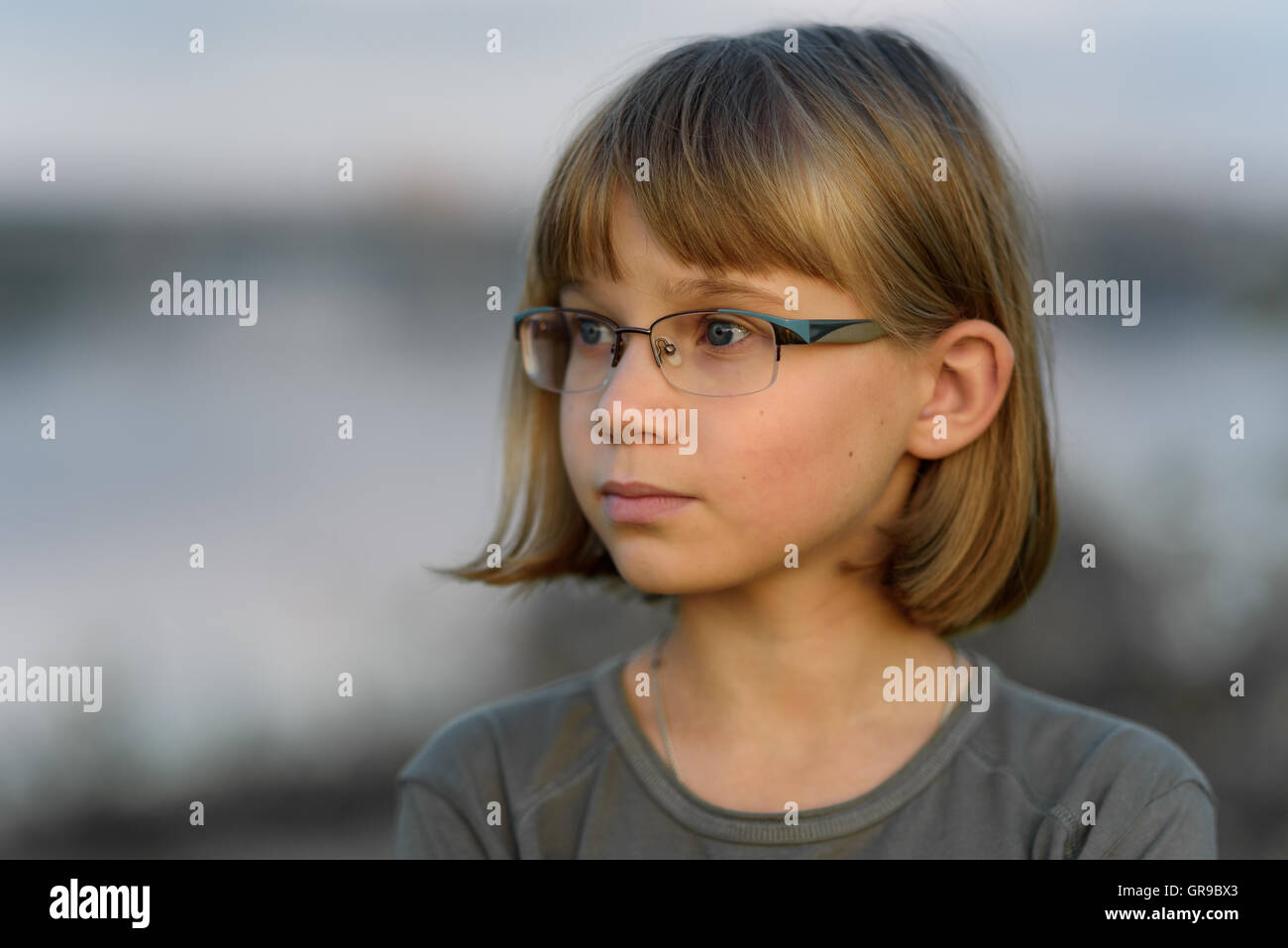 Sad Teenager Girl With Short Blonde Hair And Blue Eyes Against The