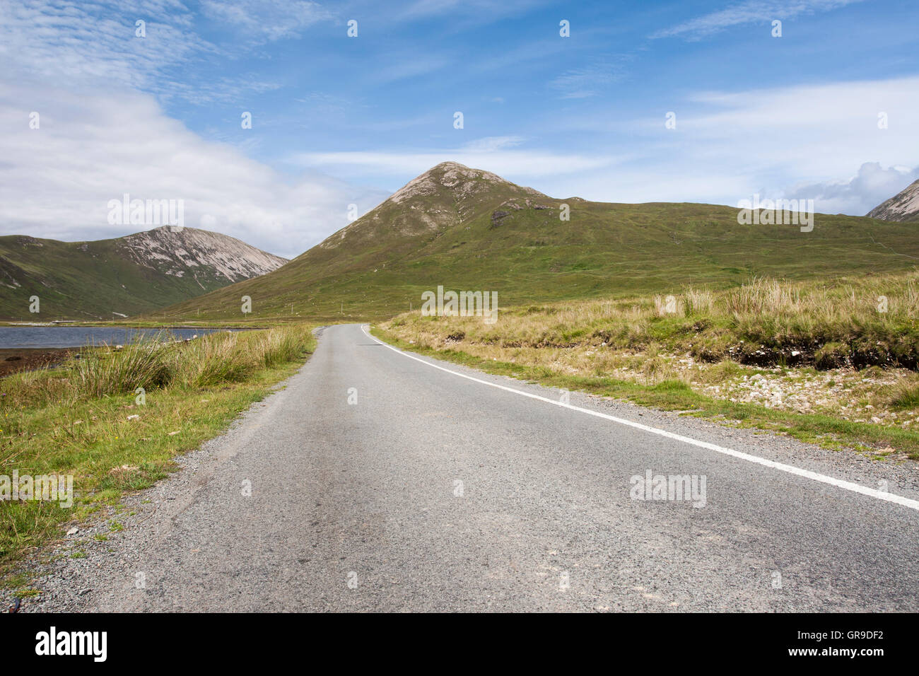 Empty single track road (B8083) with Beinn na Cro behind, Strathaird, Isle of Skye, Scotland, United Kingdom Stock Photo