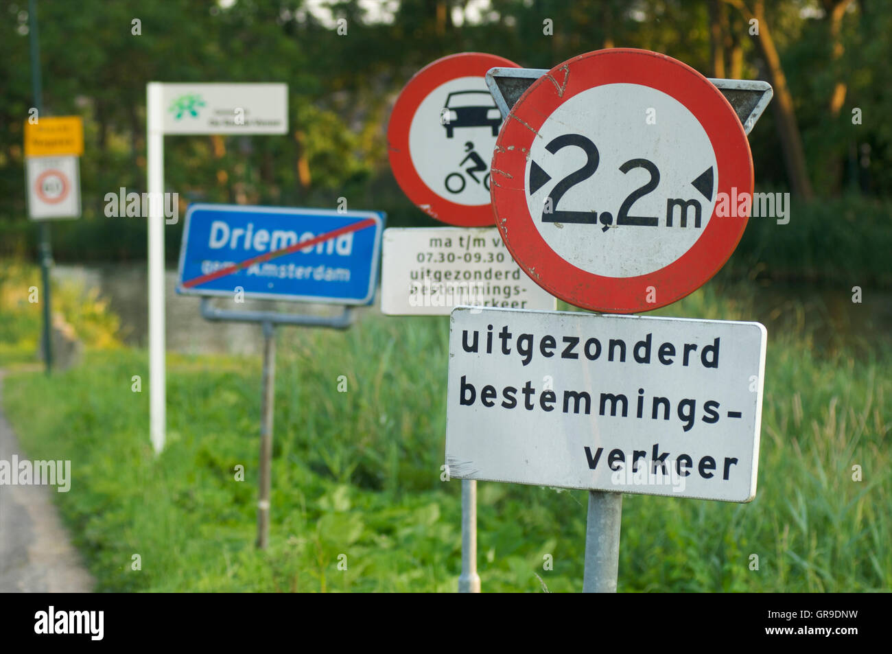 Many road signs along a small road Stock Photo