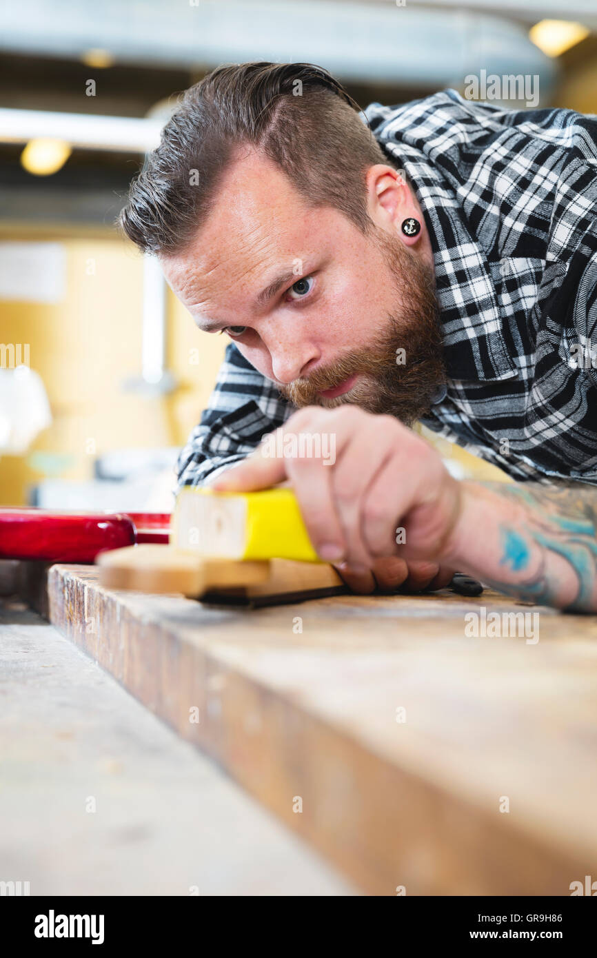 Carpenter sanding a guitar neck in wood at Stock Photo Alamy