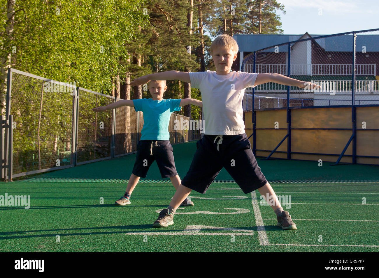 Children doing morning exercises outdoor. Stock Photo