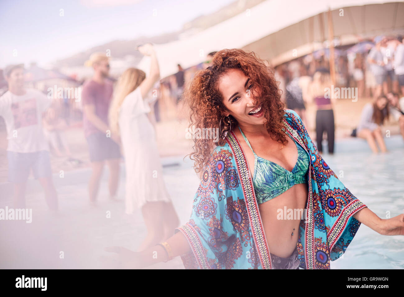 Portrait young woman dancing at poolside party Stock Photo