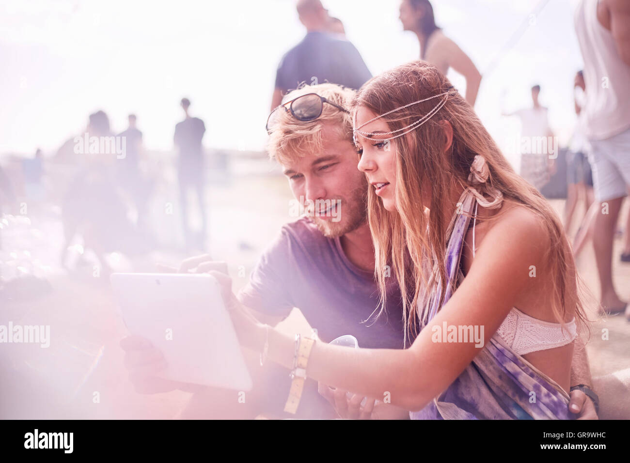 Young couple using digital tablet at poolside party Stock Photo