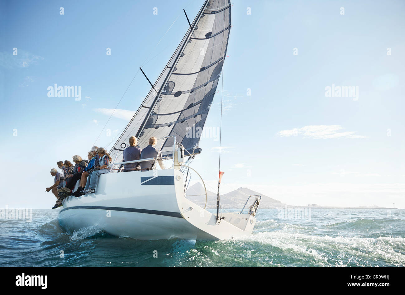 Retired friends on sailboat under blue sky Stock Photo