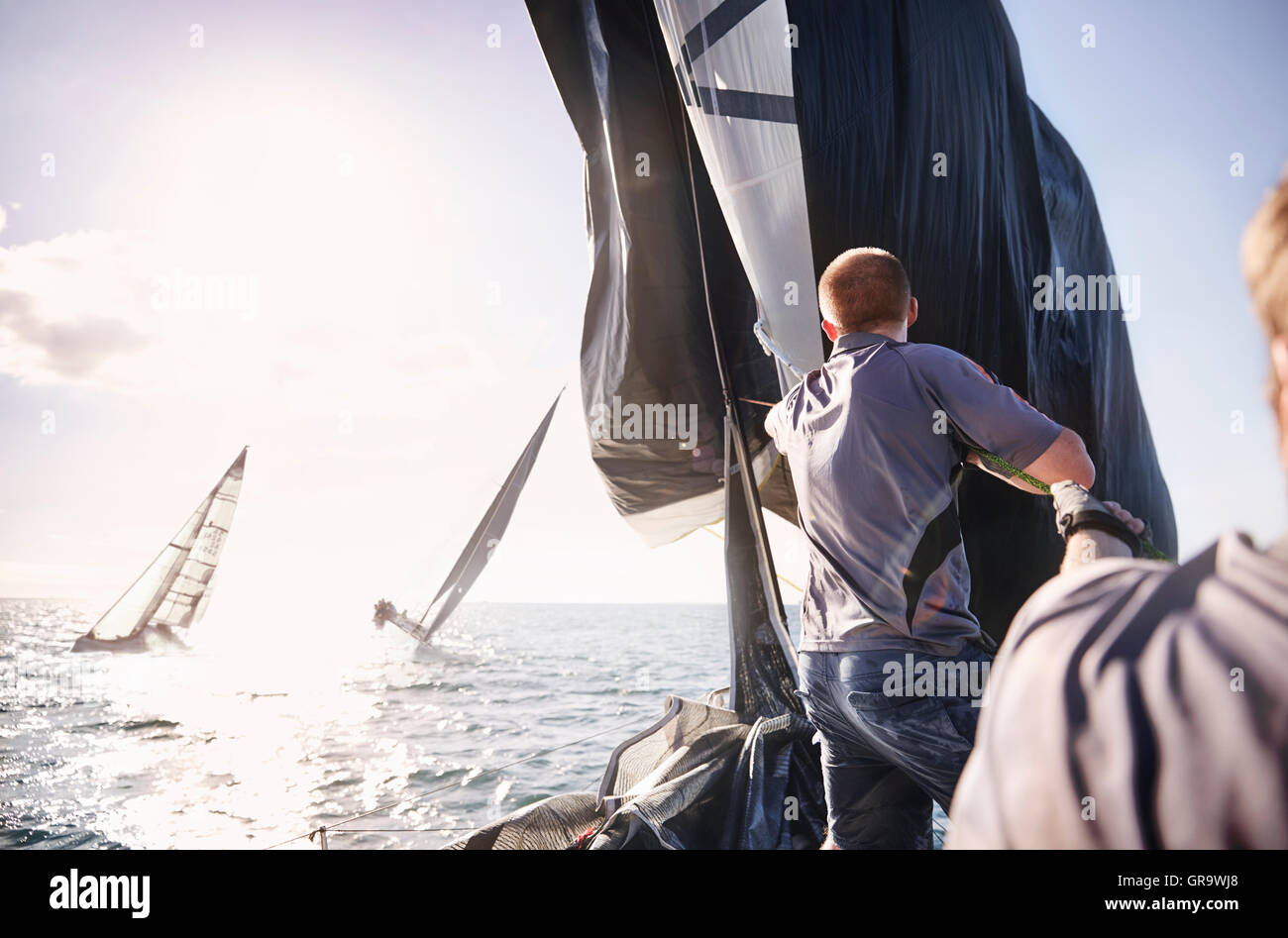 Man sailing on sunny ocean Stock Photo