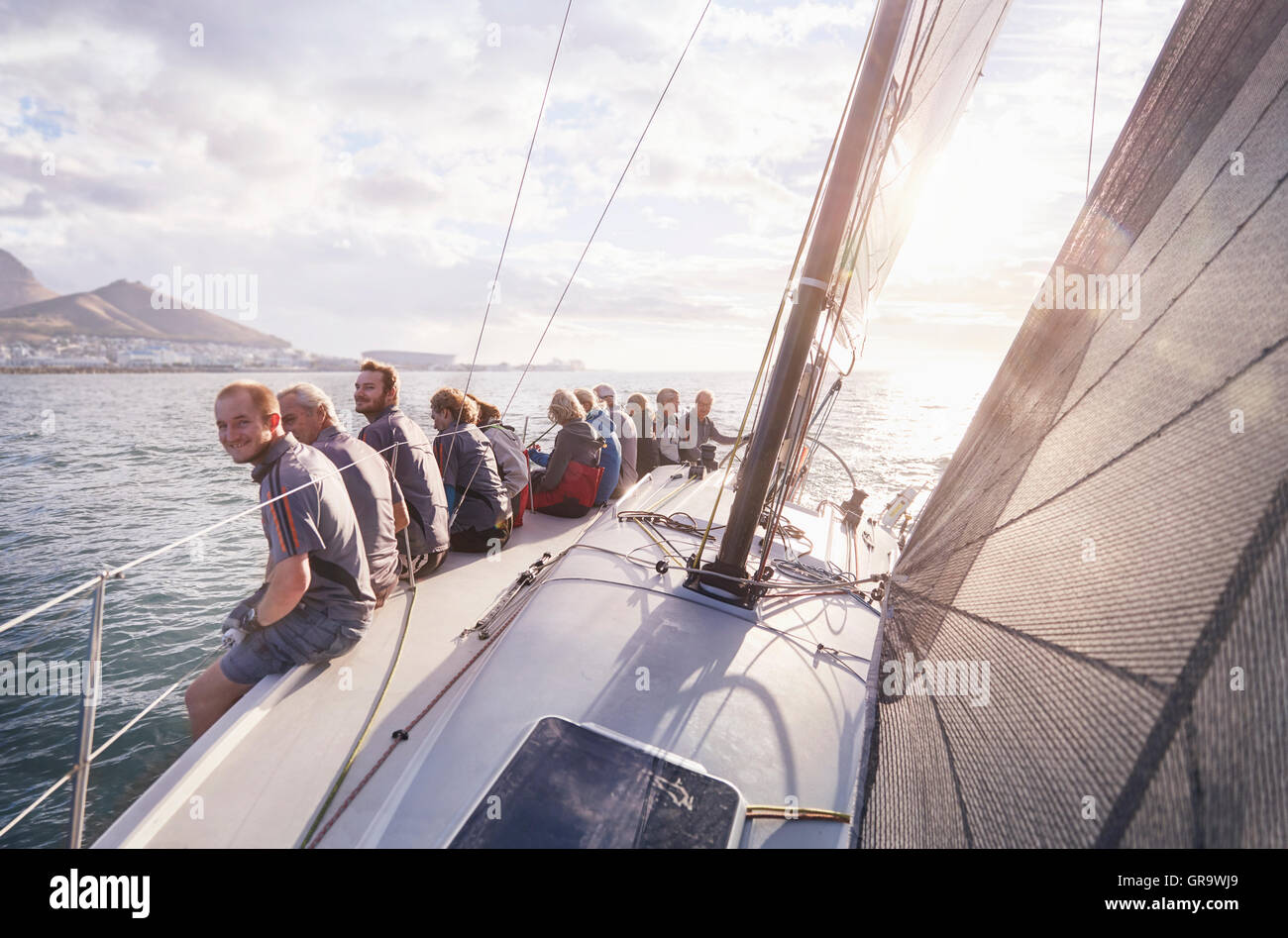 Retired friends sitting on sailboat on sunny ocean Stock Photo