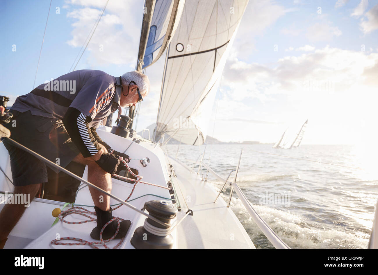 Retired man sailing on sunny ocean Stock Photo