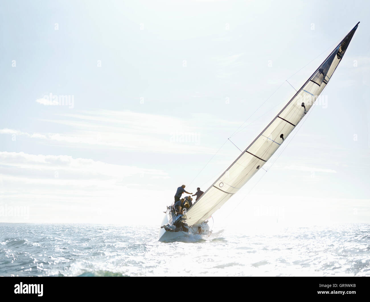 Sailboat tilting on sunny ocean Stock Photo