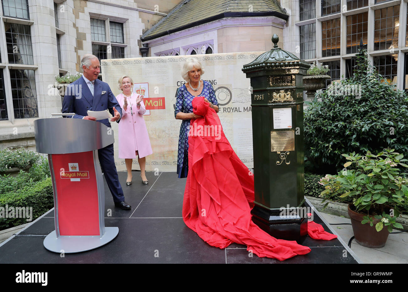 The Prince of Wales and the Duchess of Cornwall unveil a penfold postbox as they attend a reception to mark the 500th Anniversary of the Royal Mail at Merchant Taylor's Hall in London. Stock Photo