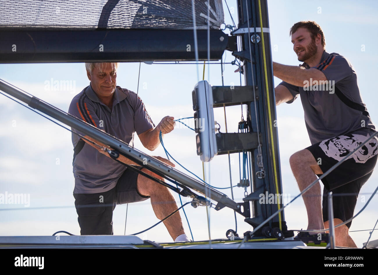Men adjusting sailing equipment Stock Photo