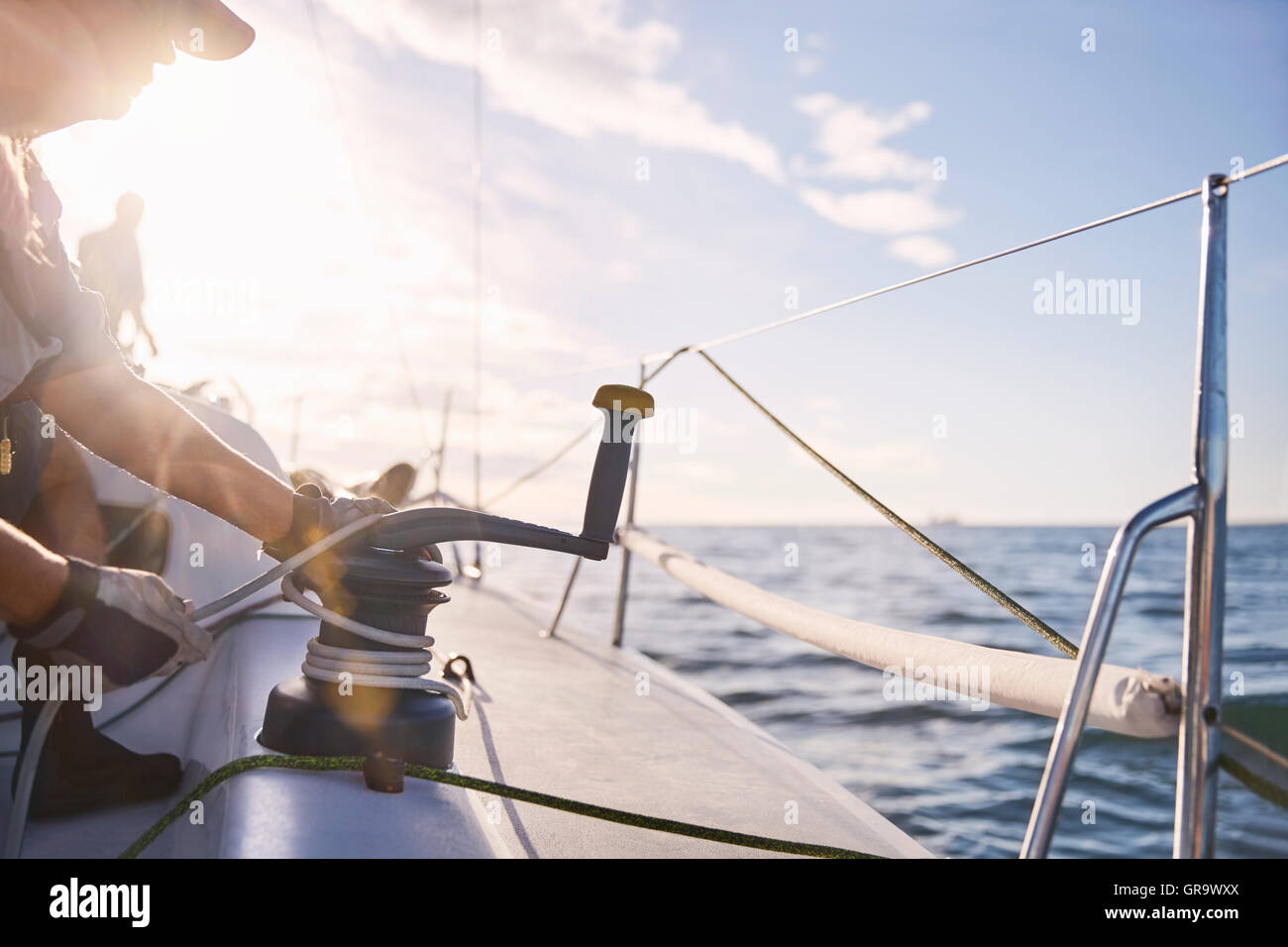 Man adjusting sailing winch on sailboat Stock Photo