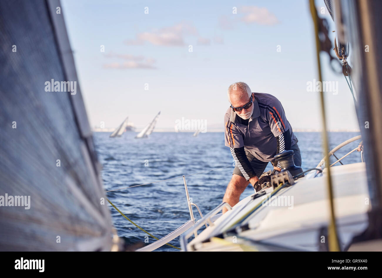 Retired man sailing sailboat Stock Photo