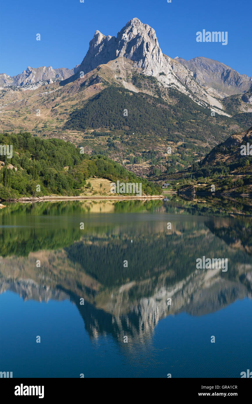 Penya Foratata reflected in the Lanuza reservoir in the Pyrenees of Huesca, Pyrenees of Huesca, Spain. Stock Photo
