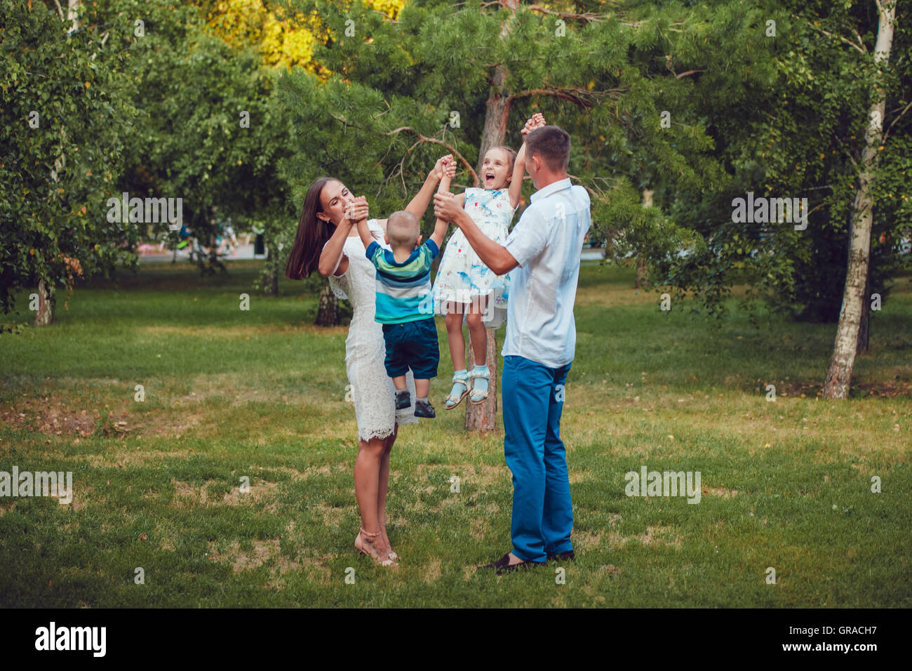 Young family of four having fun in the park Stock Photo - Alamy