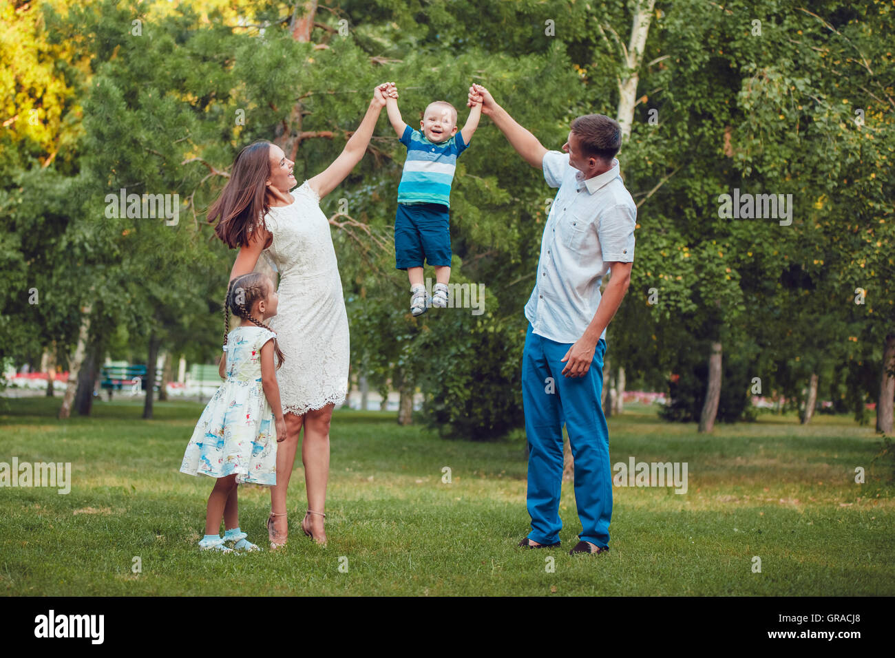 Young family of four having fun in the park Stock Photo - Alamy