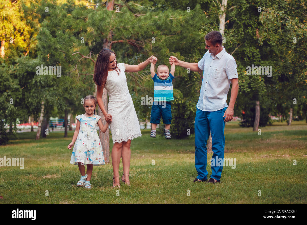 Young family of four having fun in the park Stock Photo - Alamy