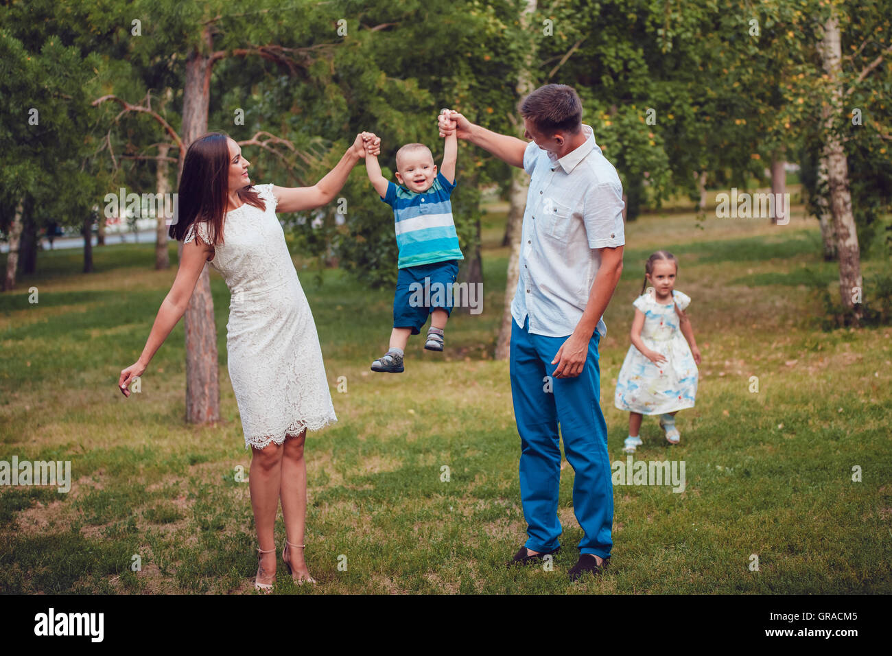 Young family of four having fun in the park Stock Photo - Alamy