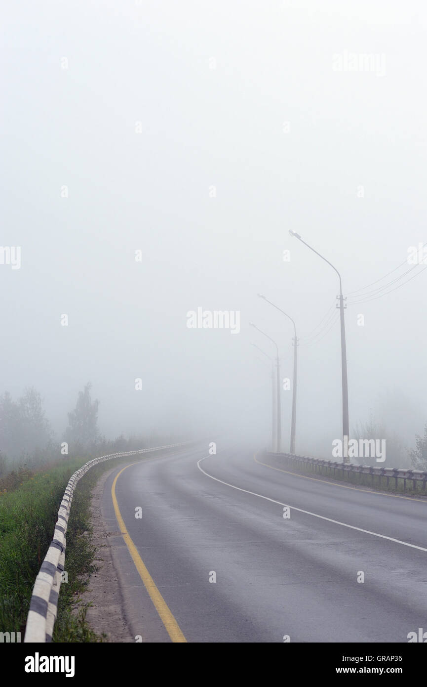 Empty morning road covered with morning fog Stock Photo - Alamy