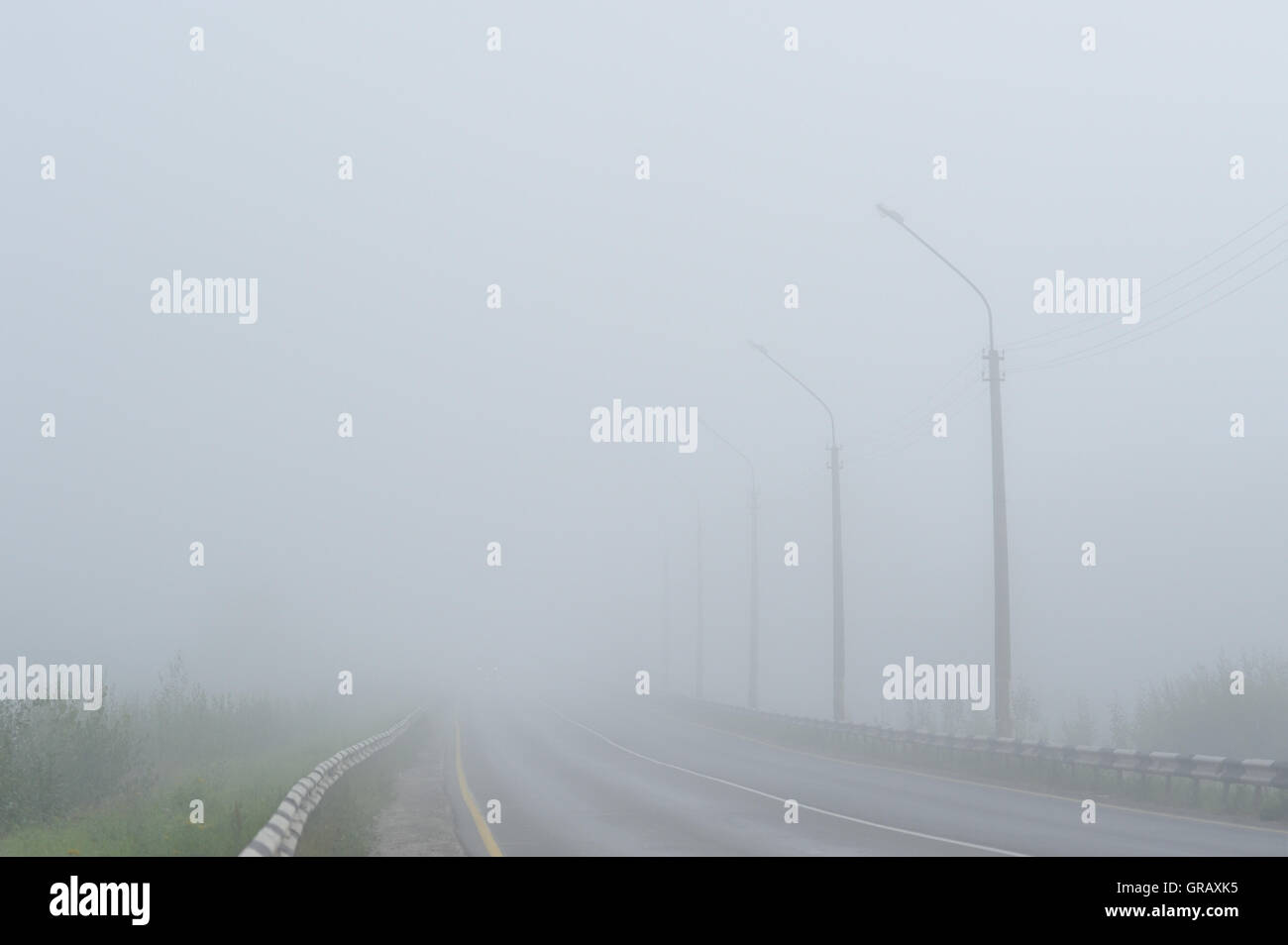 Empty morning road covered with morning fog Stock Photo - Alamy