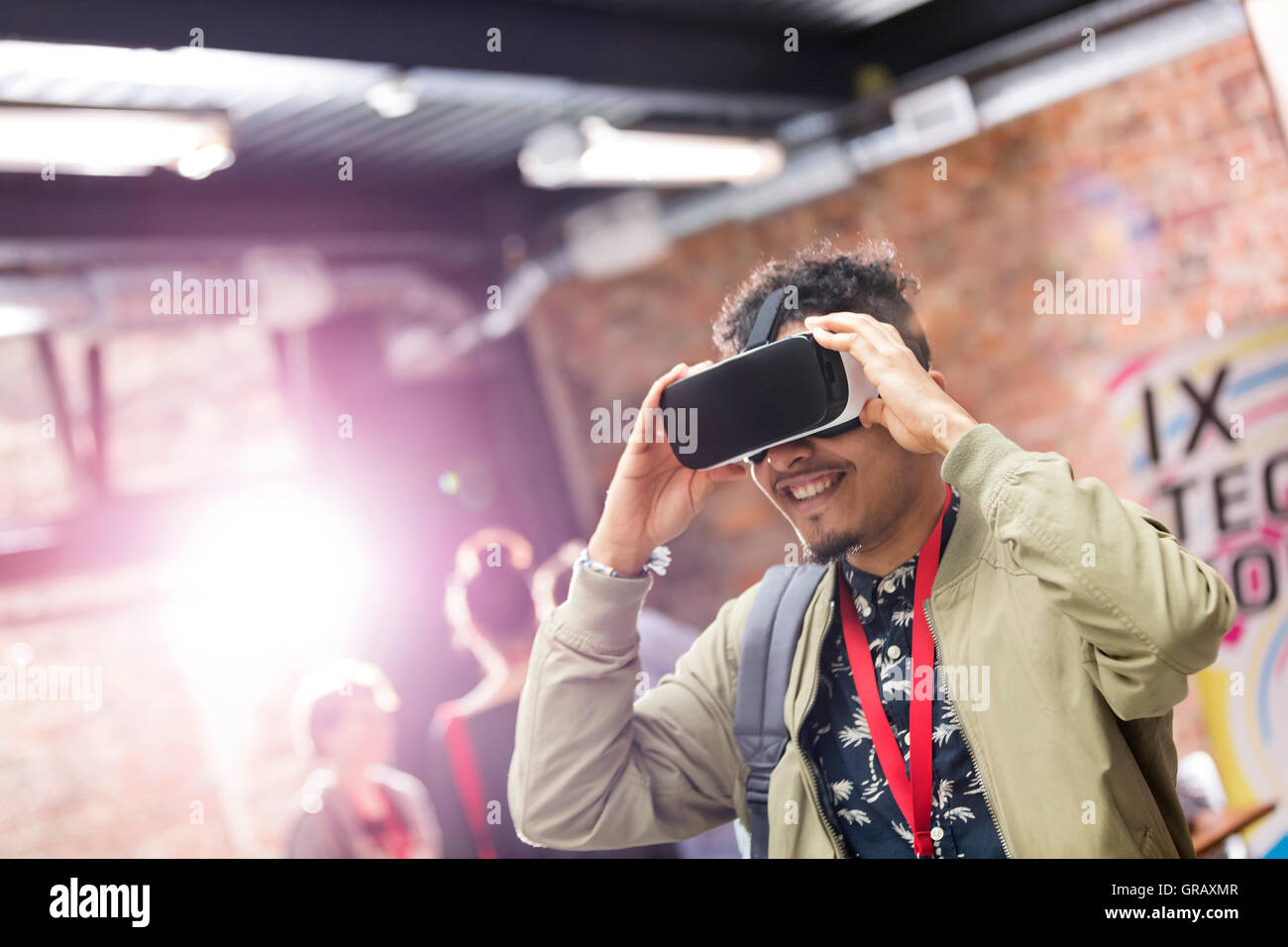 Man trying virtual reality simulator glasses at technology conference Stock Photo