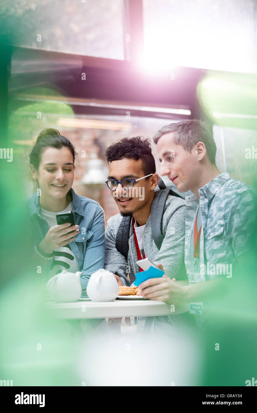 Men and women texting with cell phone in cafeteria Stock Photo