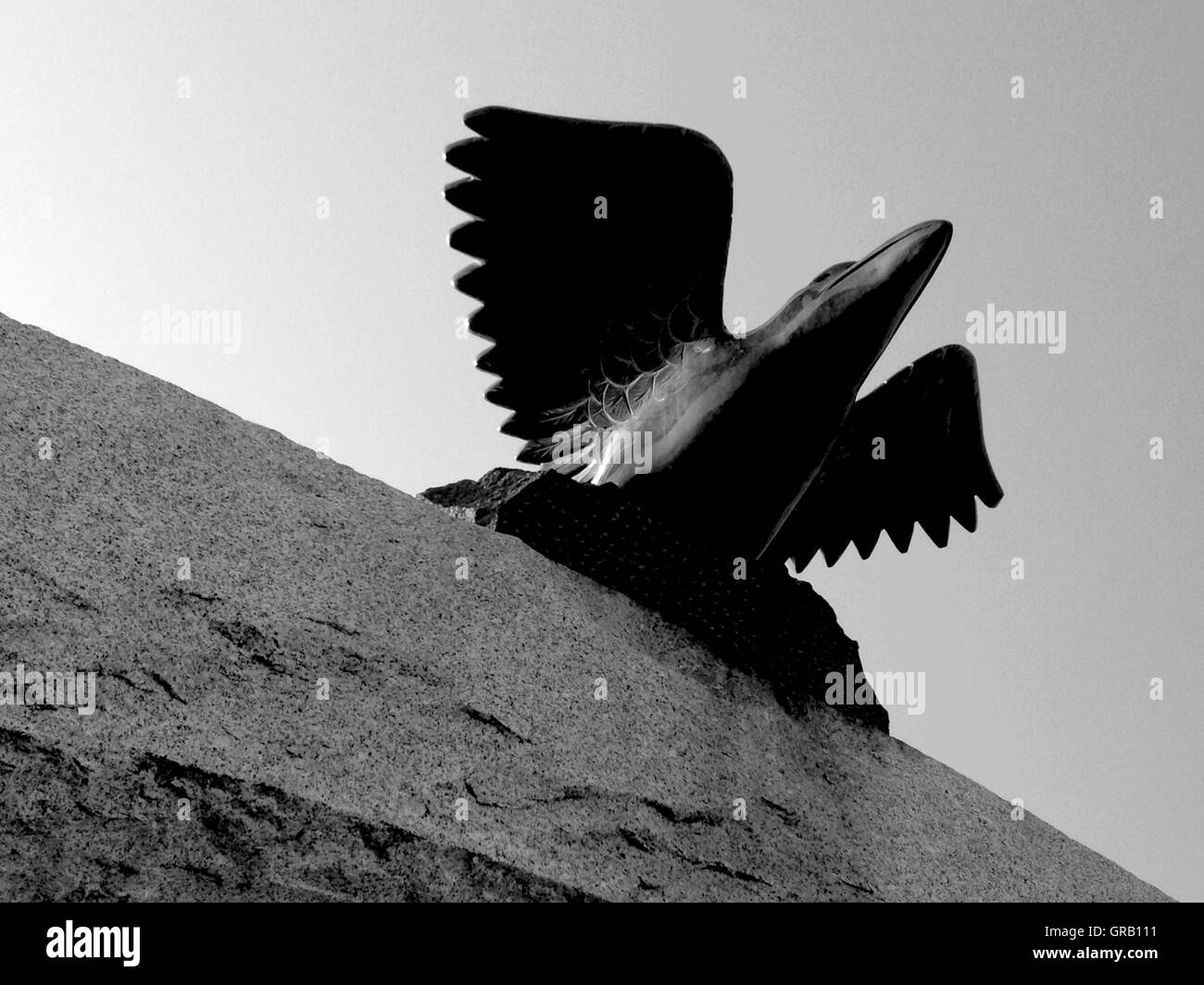 Low Angle View Of Bird Sculpture On Wall Against Clear Sky Stock Photo