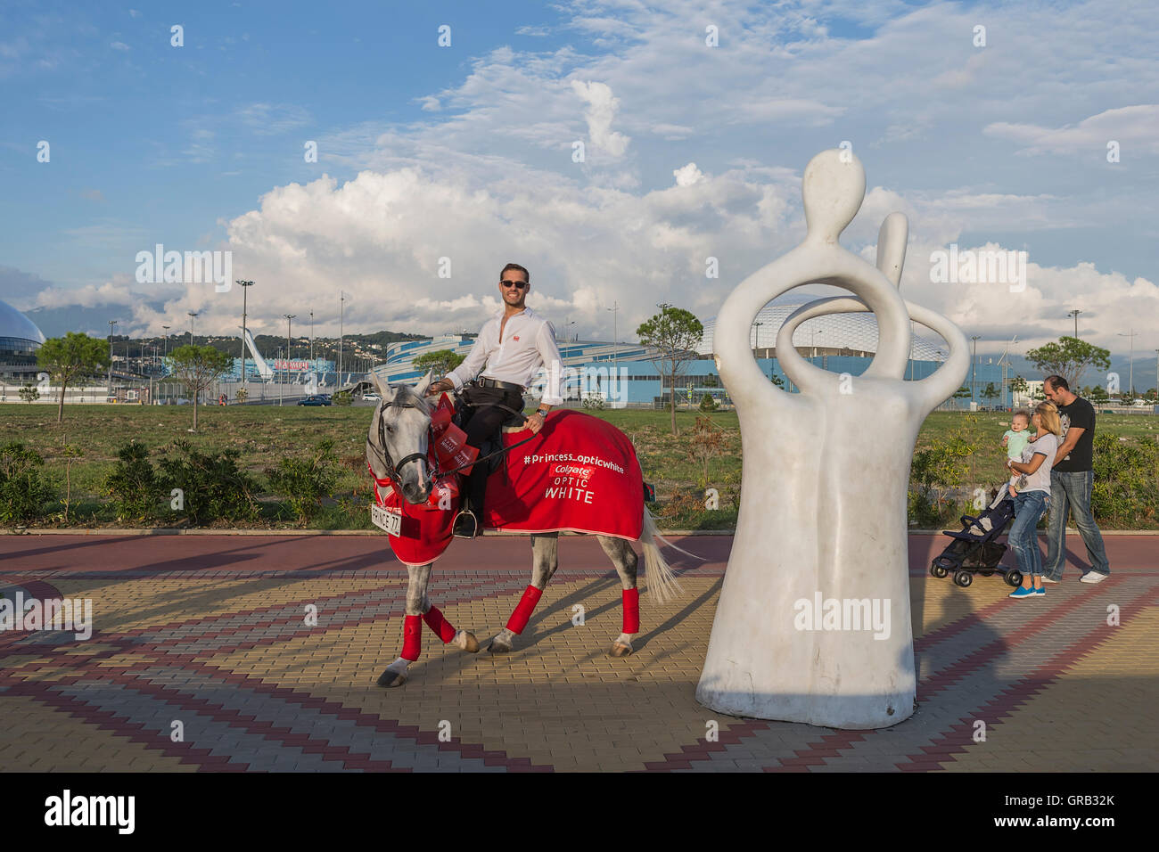 A man on a gray horse in motion, advertises goods, Sochi, the Olympic Village, Russia Stock Photo