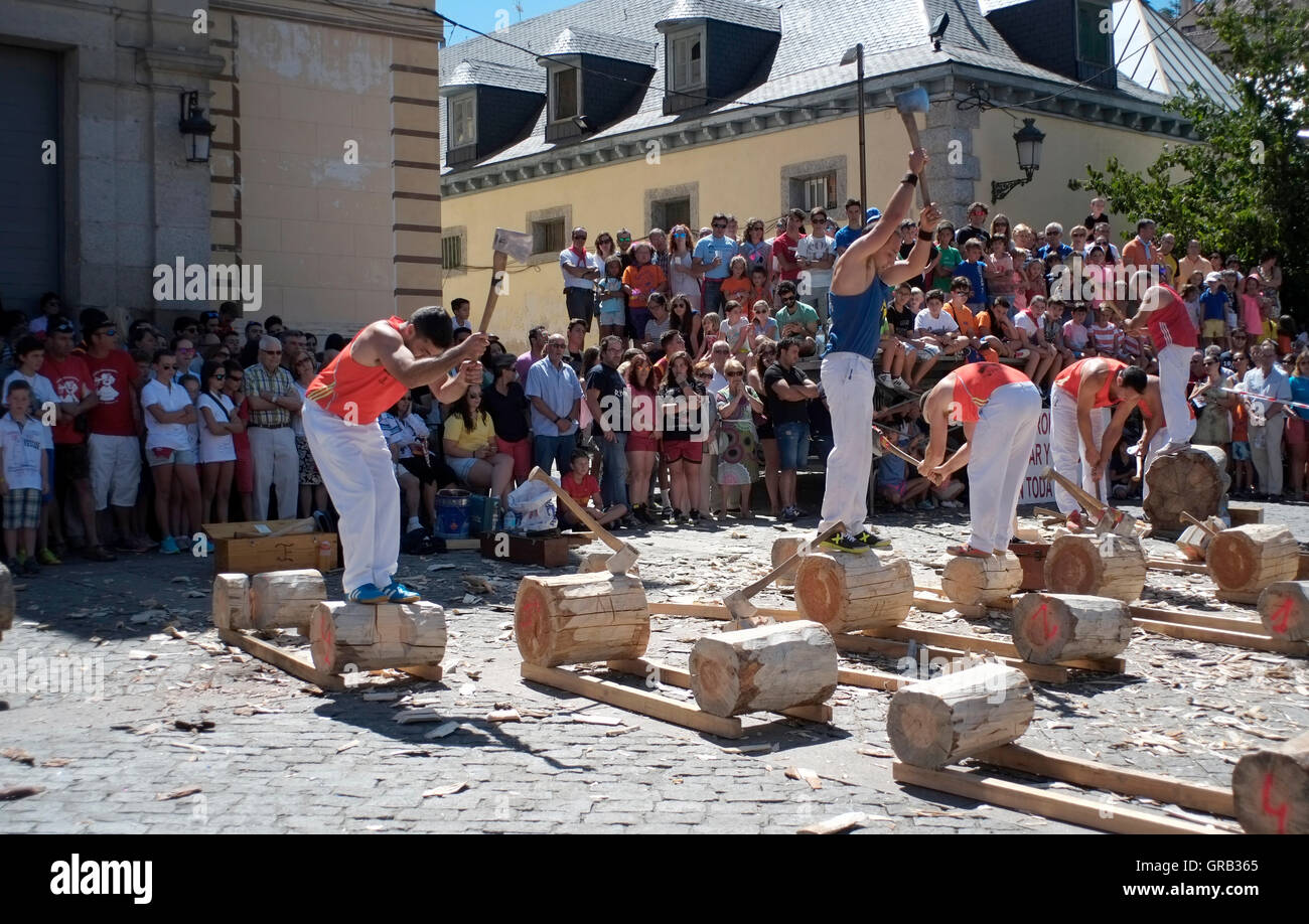 Men chop logs in a competition in La Granja de San Ildefonso, Spain August 21, 2016 - Copyright photograph John Voos Stock Photo