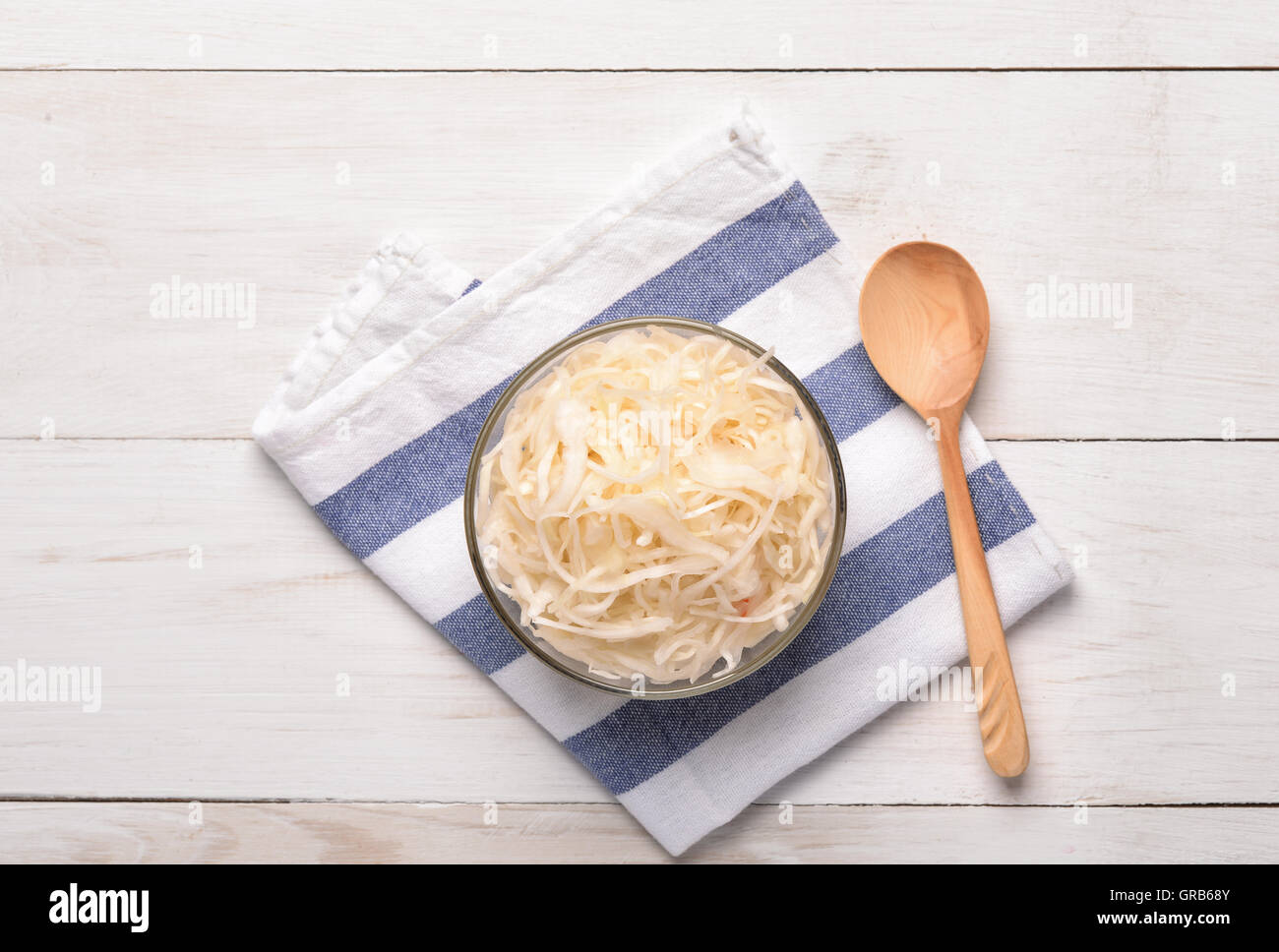 Top view of sauerkraut in glass bowl on white wooden  table Stock Photo