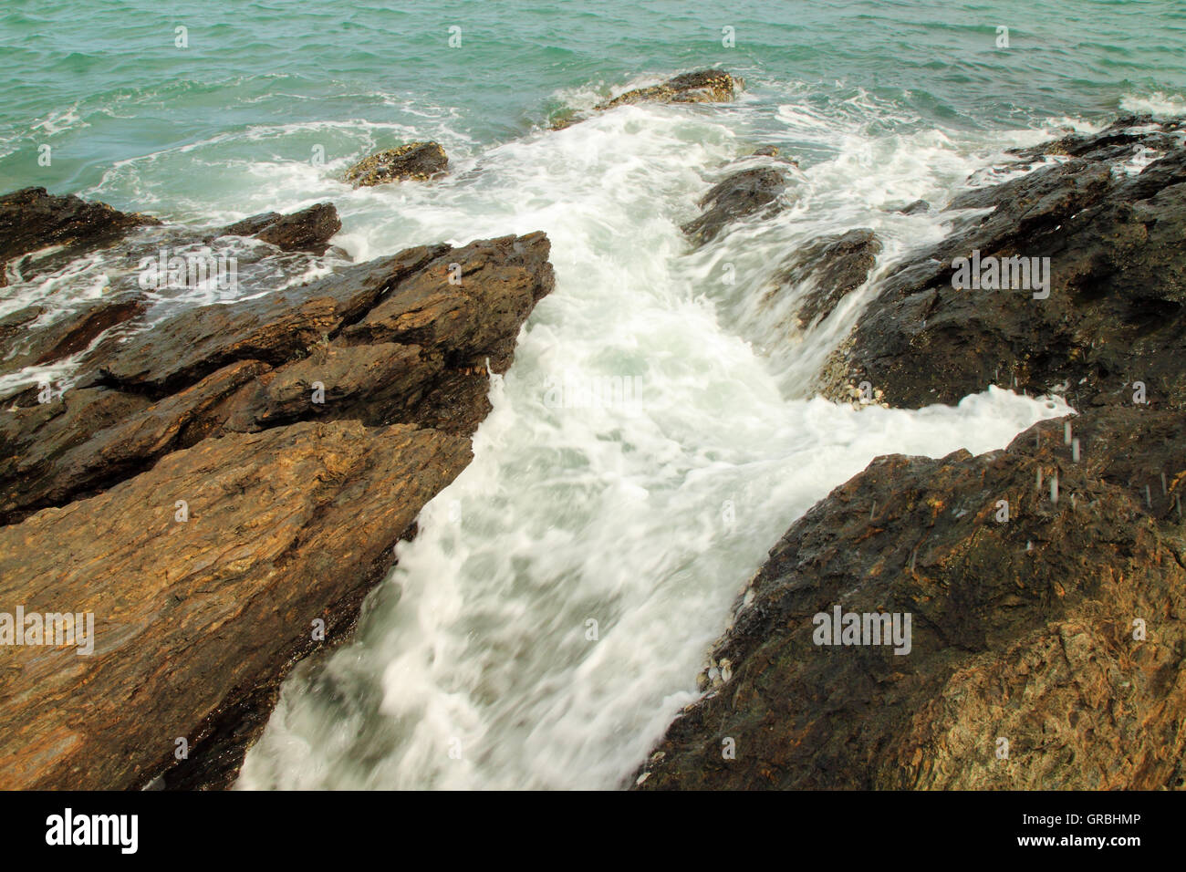Sea waves hitting round rocks and splashing Stock Photo - Alamy