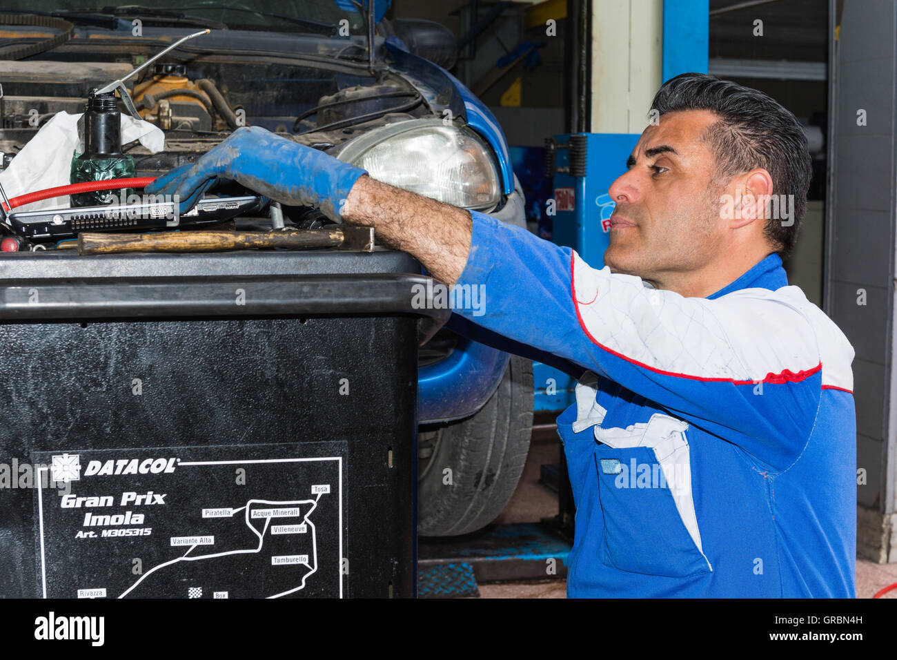 Car mechanic fixing an engine in his garage. copy space Stock Photo - Alamy