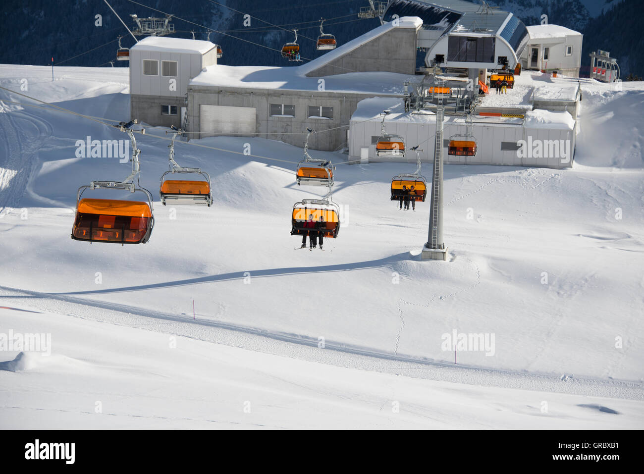 Chair Lift With Orange Weather Protectors On A Sunny Winterday, Midwaystation Stock Photo