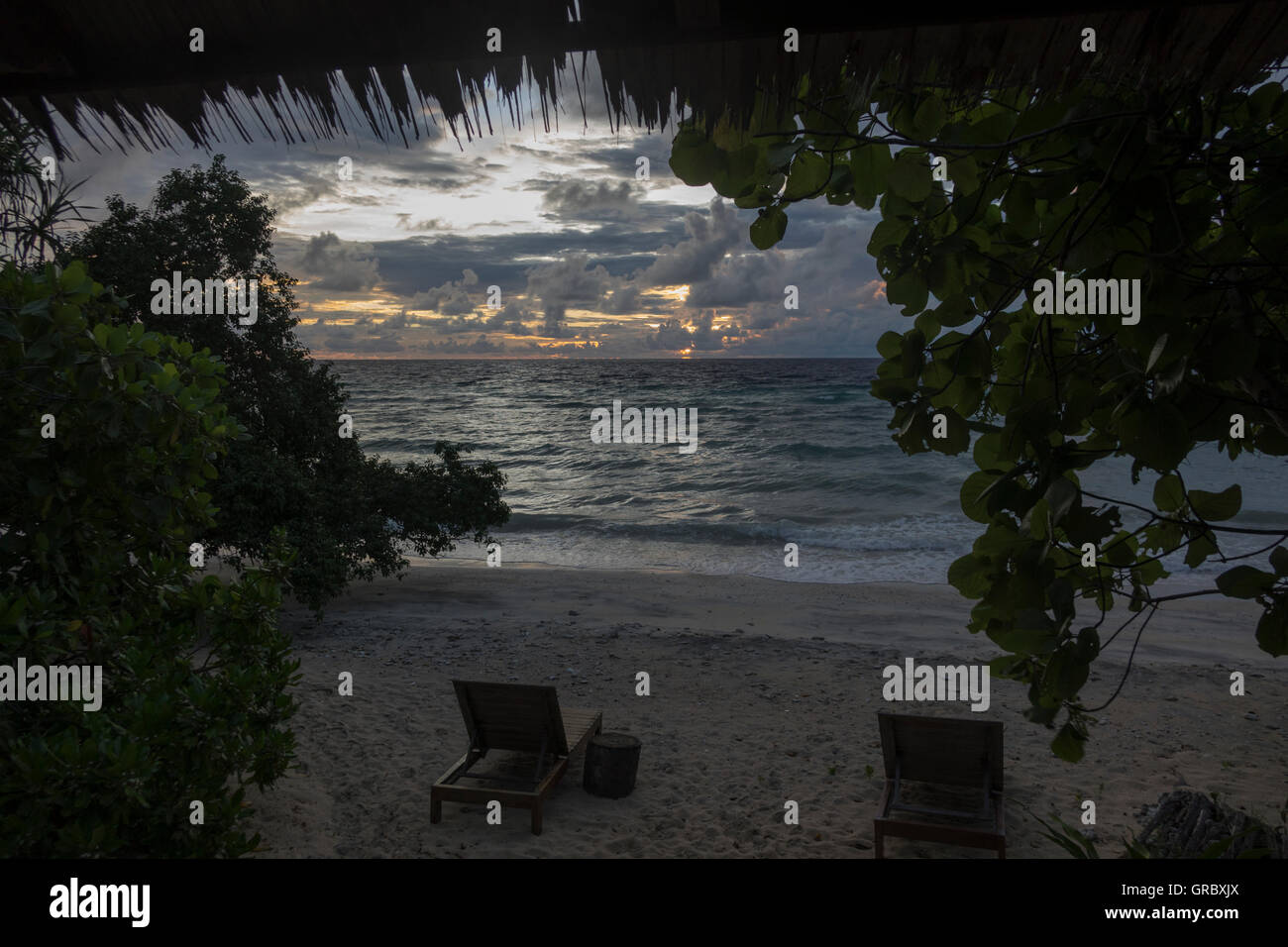 Evening Twilight At The Ocean, Sandy Beach With Deckchairs, Vegetation. Selayar, South Sulawesi, Indonesia Stock Photo