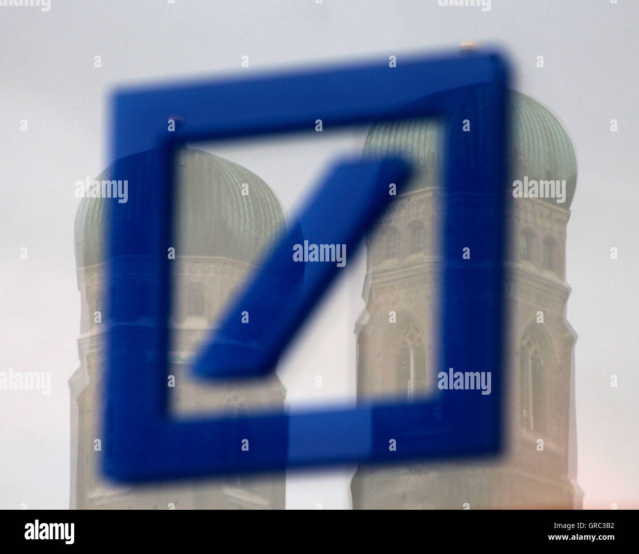 Logo Of Deutsche Bank With Mirrrowing Toers Of Frauenkirche In Munich Stock Photo