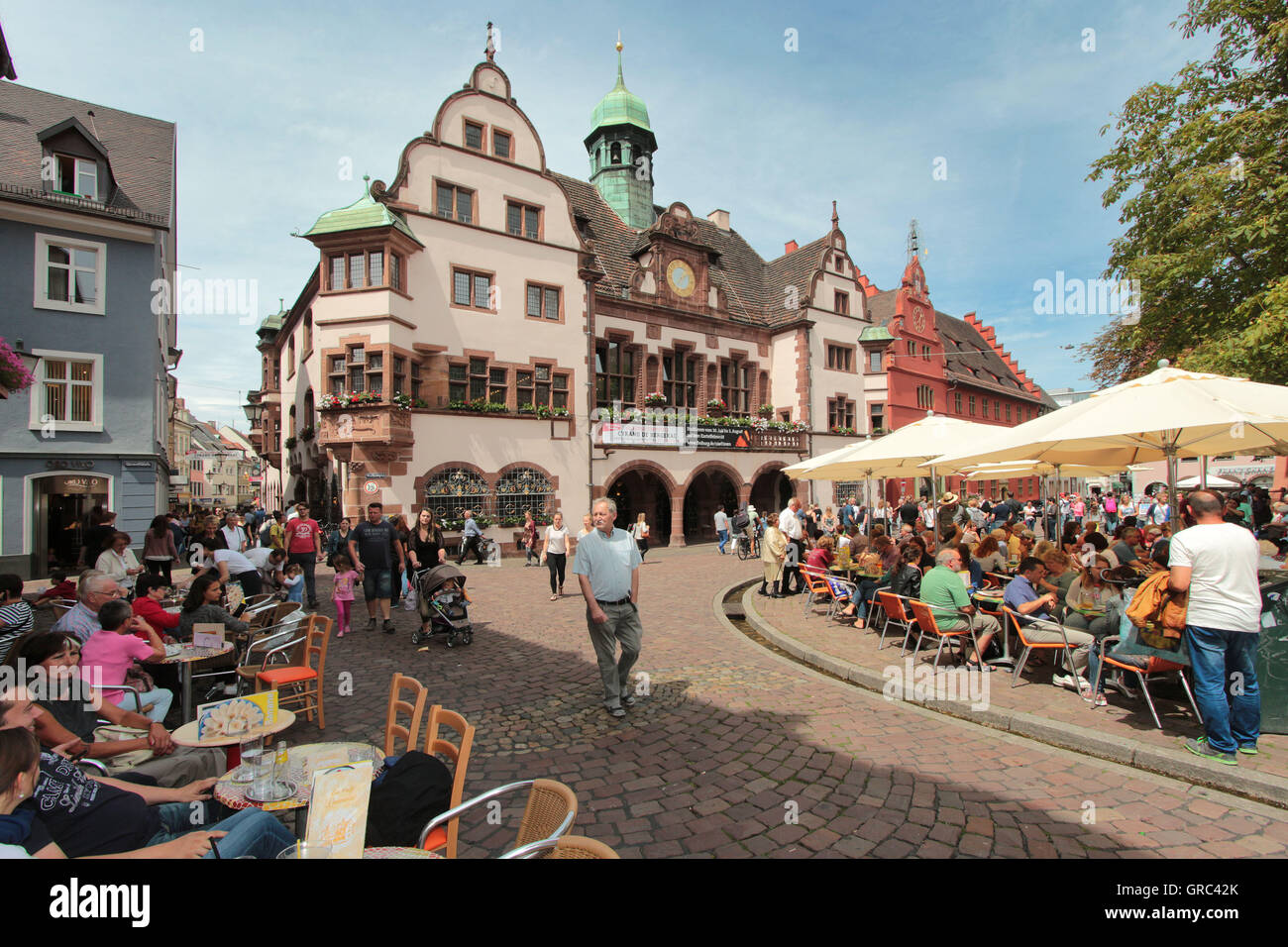 Rathausplatz In Freiburg With Crowded Cafes On A Warm Summer Day Stock Photo