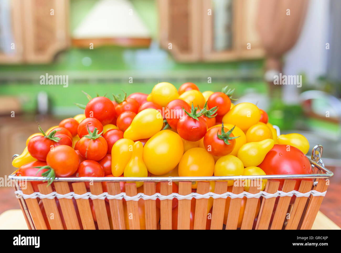 Tomatoes in a basket in the kitchen. Close-up Stock Photo - Alamy