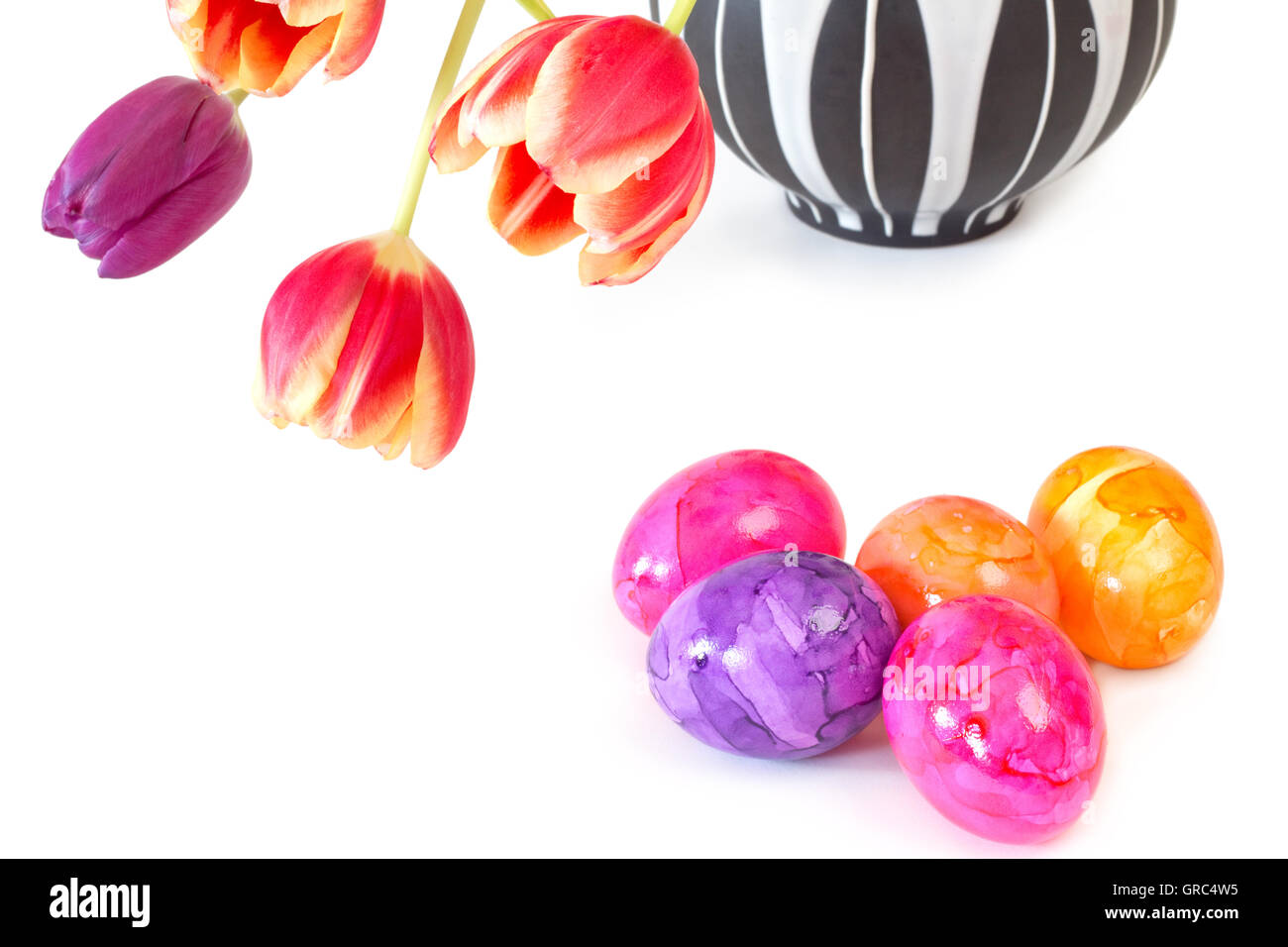 Colourful Easter Eggs And Tulips In A Vase On White Background Stock Photo